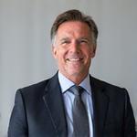 Portrait of a distinguished-looking financial advisor, male, in a business suit, smiling confidently. 